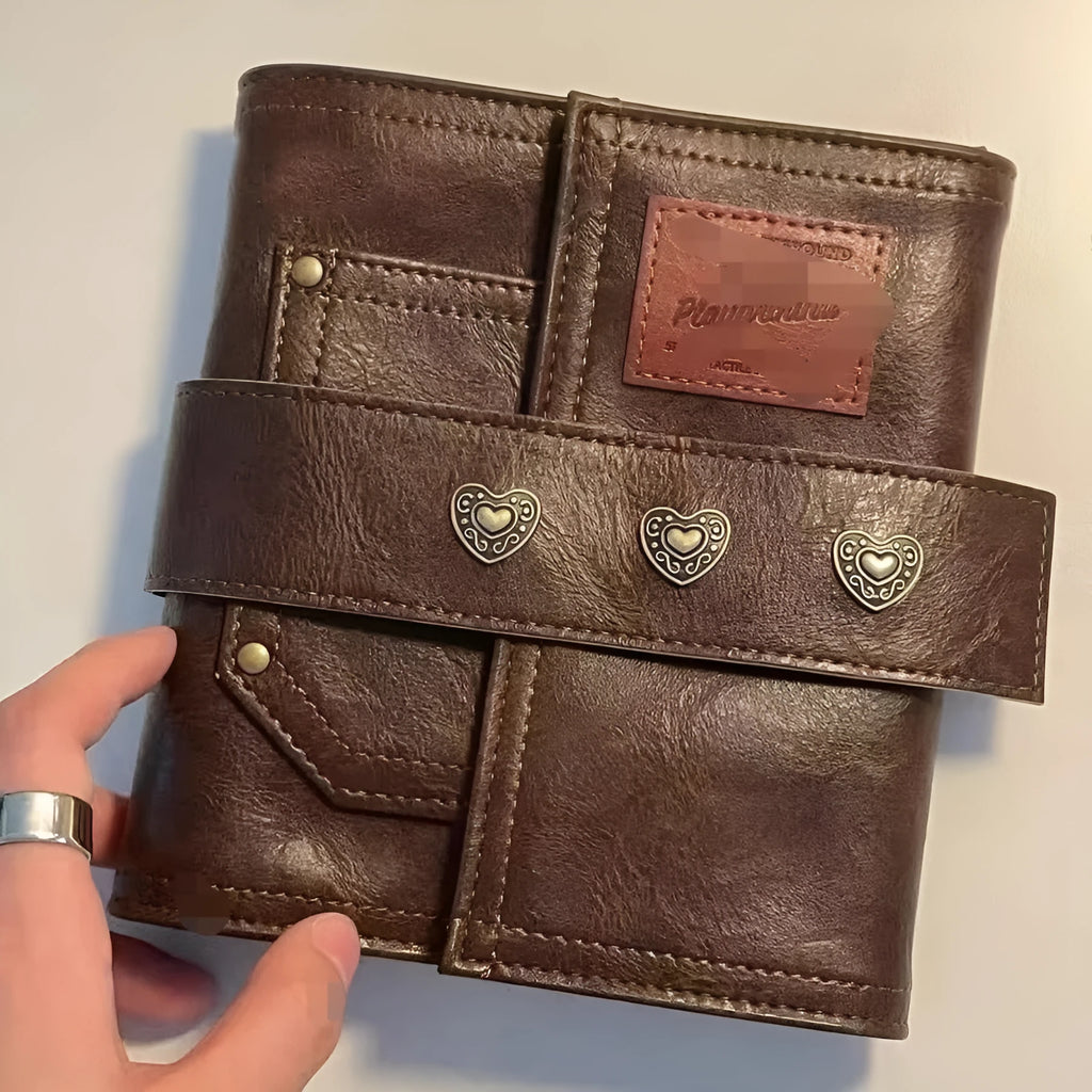 Brown A7 size notebook with a retro PU cover and leather buckle, showing loose-leaf binding.