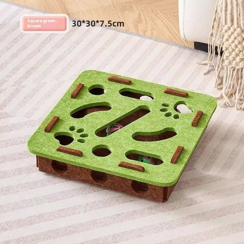 Green brown felt cube cat scratching toy with a square hole in the centre panel.