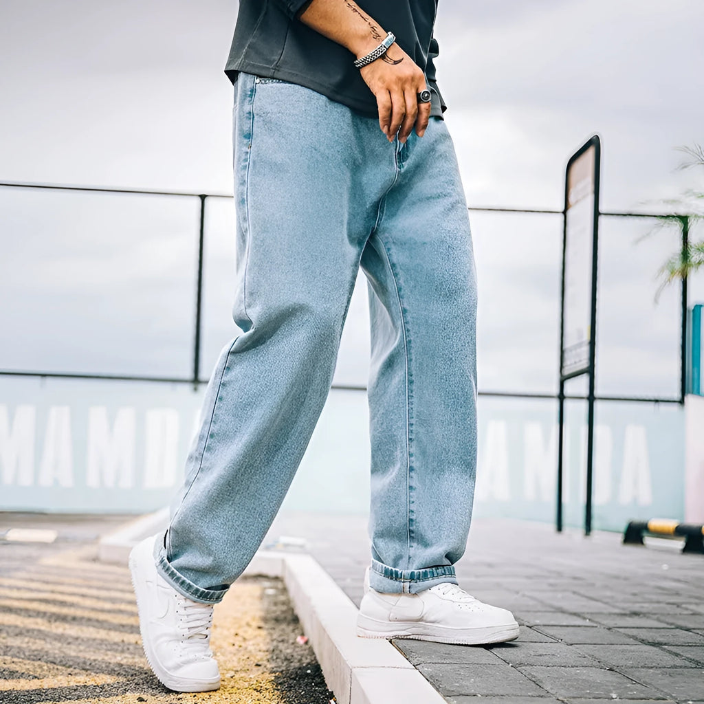 Men's loose fit straight leg casual jeans in dark blue, shown on a hanger.