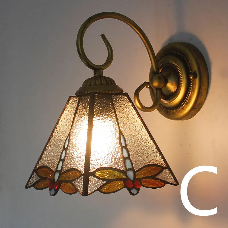 A coloured stained glass wall lamp mounted on a corridor wall, showing one of six available style variants.