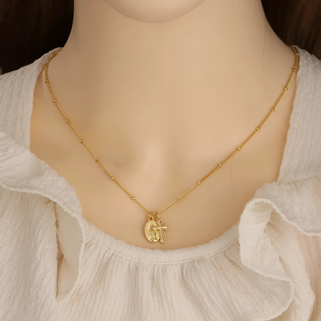 Gold geometric Virgin Mary cross necklace on a chain, simple style.