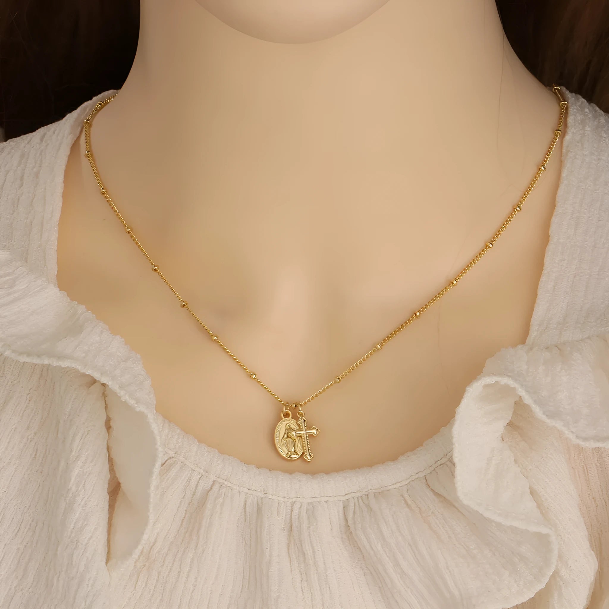 Gold geometric Virgin Mary cross necklace on a chain, simple style.