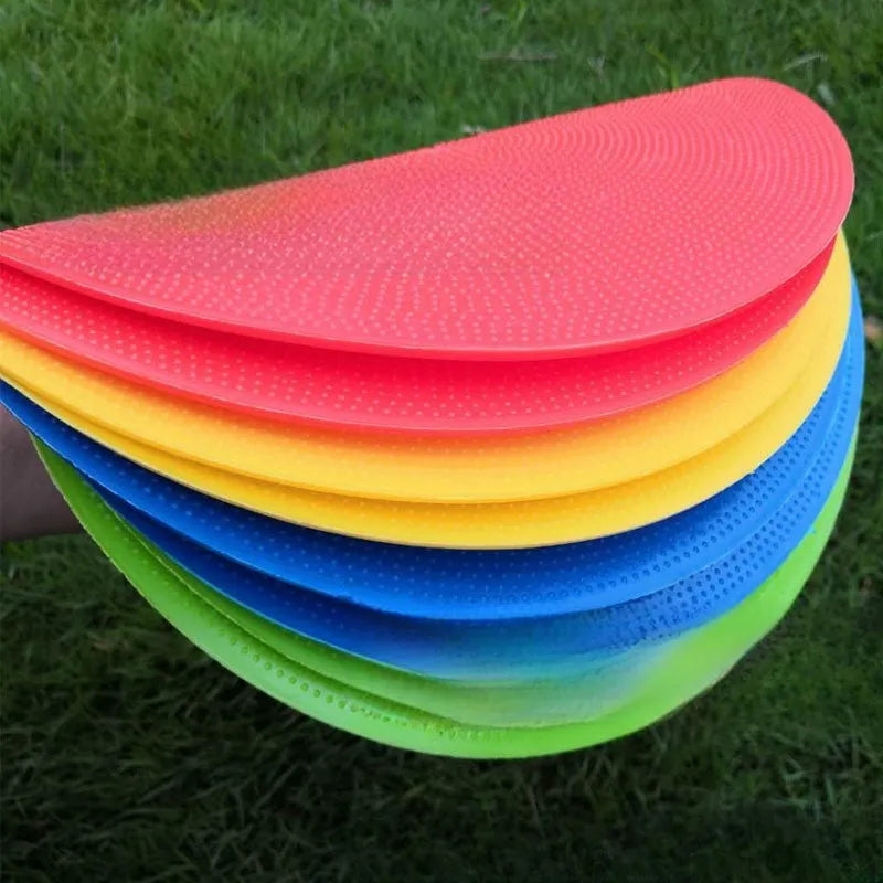 Yellow football training target disc with 23cm diameter on grass pitch