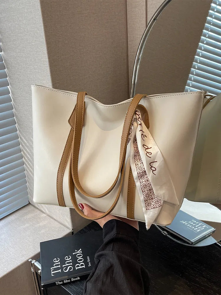 Large capacity tote crossbody bag in bucket style with sandwich pocket design and visible sewing details