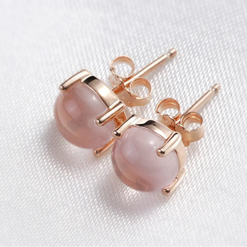 Women's rose gold plated stud earrings with a drop-shaped synthetic rose quartz stone.
