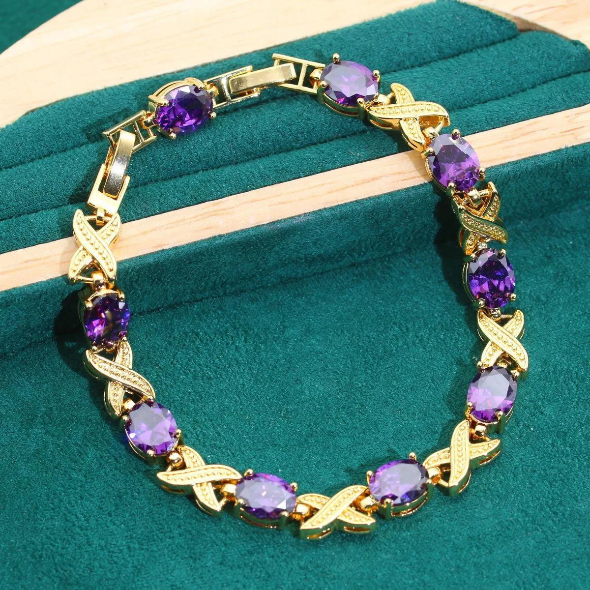 Gold plated cubic zirconia jewellery set with necklace, earrings, ring, and bracelet in blue, green, purple, or red.