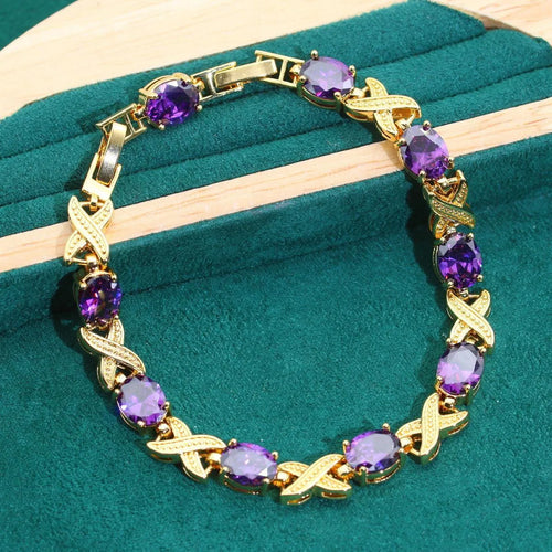 Gold plated cubic zirconia jewellery set with necklace, earrings, ring, and bracelet in blue, green, purple, or red.