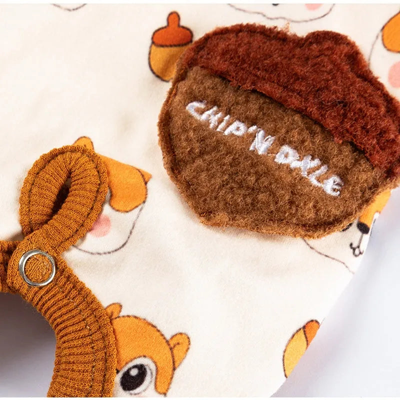 Chip 'n' Dale sleeveless dog jumpsuit with squirrel and acorn print, fuzzy embroidered acorn pocket, ribbed cuffs and snap closure, cream or white.