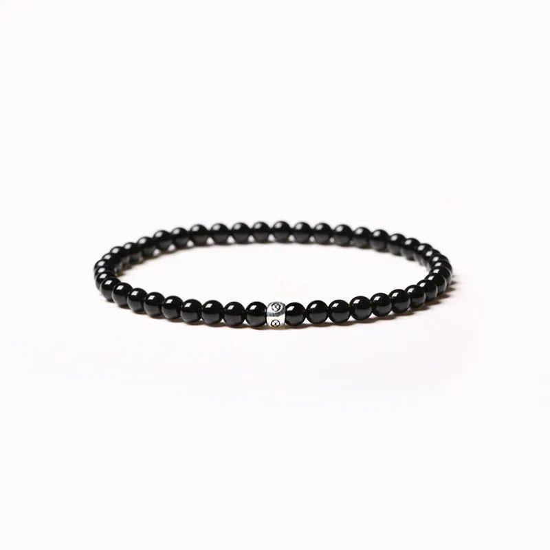 Fine geometric bracelet with black obsidian, blue san, and black agate 4mm beads on an adjustable band.