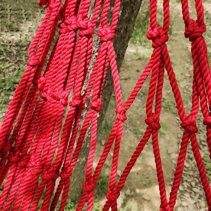Outdoor nylon rope mesh hammock hanging between trees showing mesh construction and tying ropes