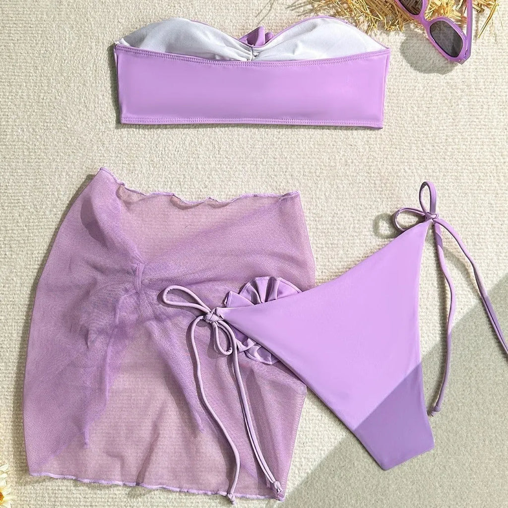 Women's pink swimsuit set with flower tie detail on tube top, matching pants and skirt