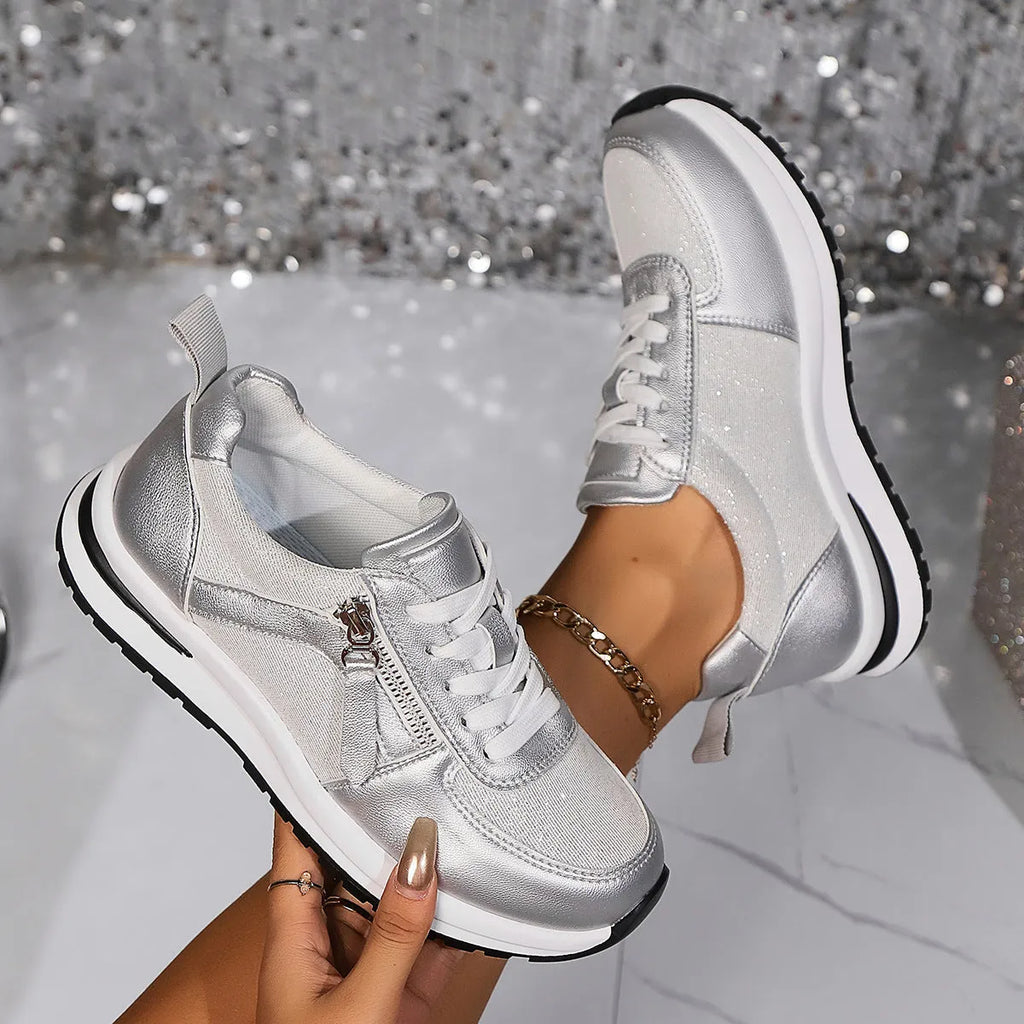 Gold women's lace-up pumps with round toe and flat rubber sole on a white background
