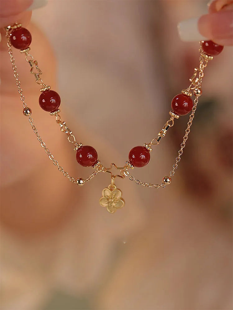 Red agate double layer bracelet with floral and peach blossom design on a wrist