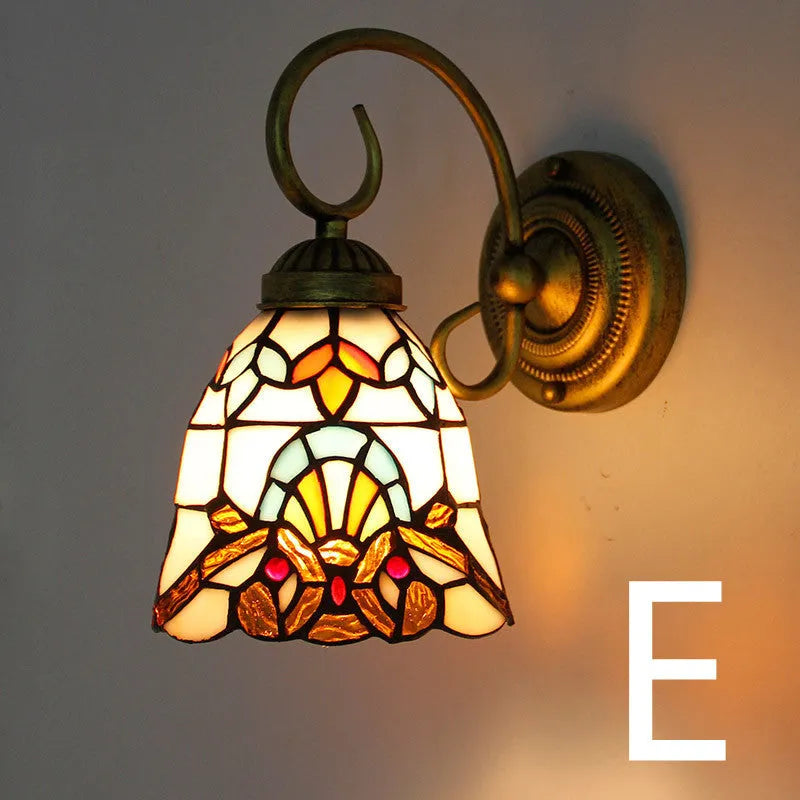 A coloured stained glass wall lamp mounted on a corridor wall, showing one of six available style variants.