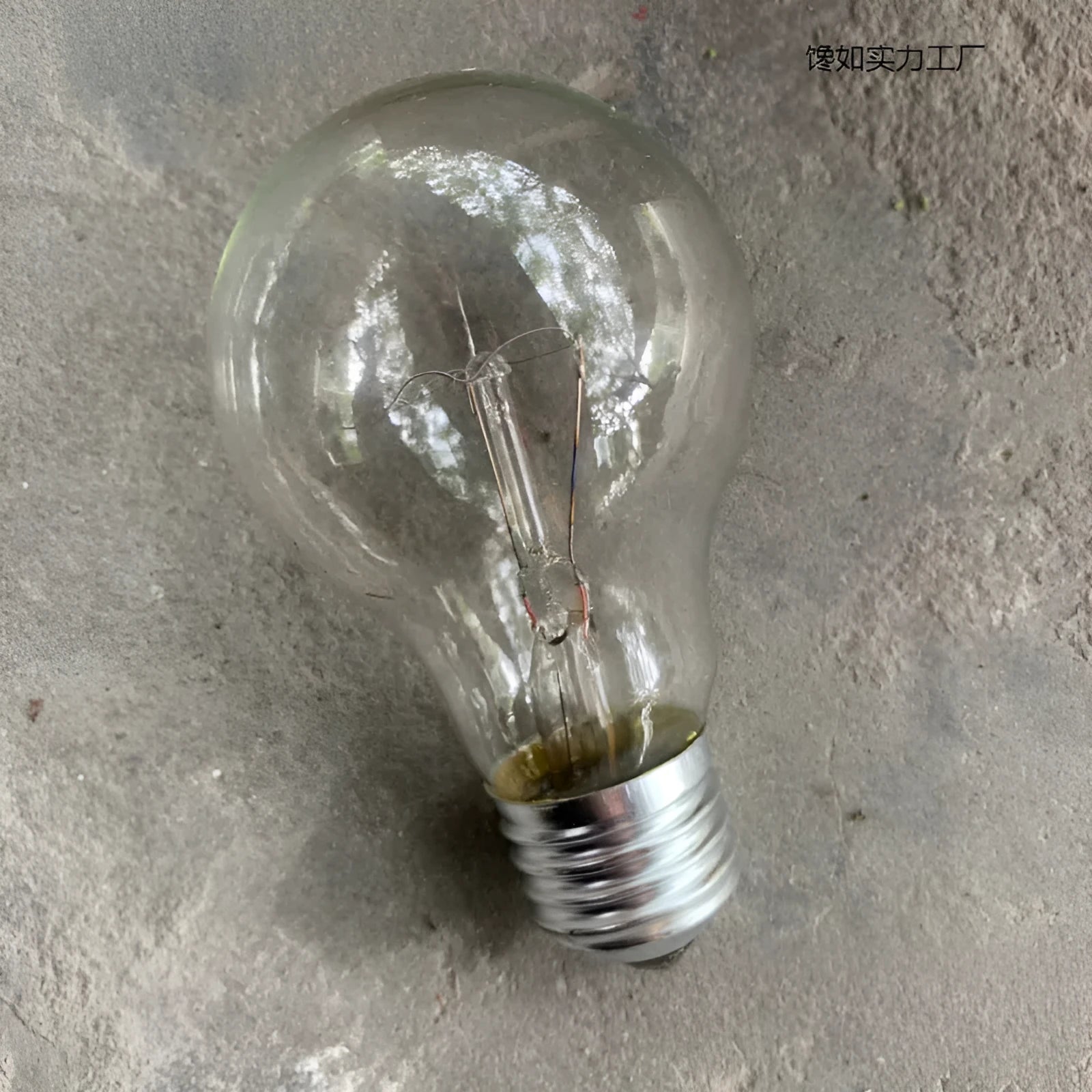 Tungsten incandescent household bulb with E27 screw base, clear glass, and visible filament