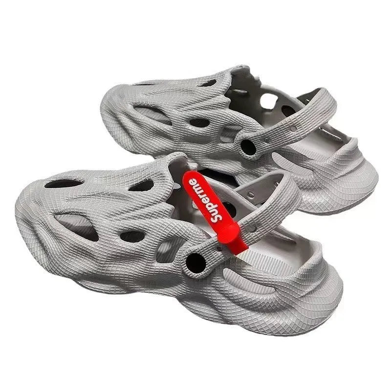 Grey closed-toe EVA coconut slippers on a beach background, showing frosted surface and injection moulded sole.