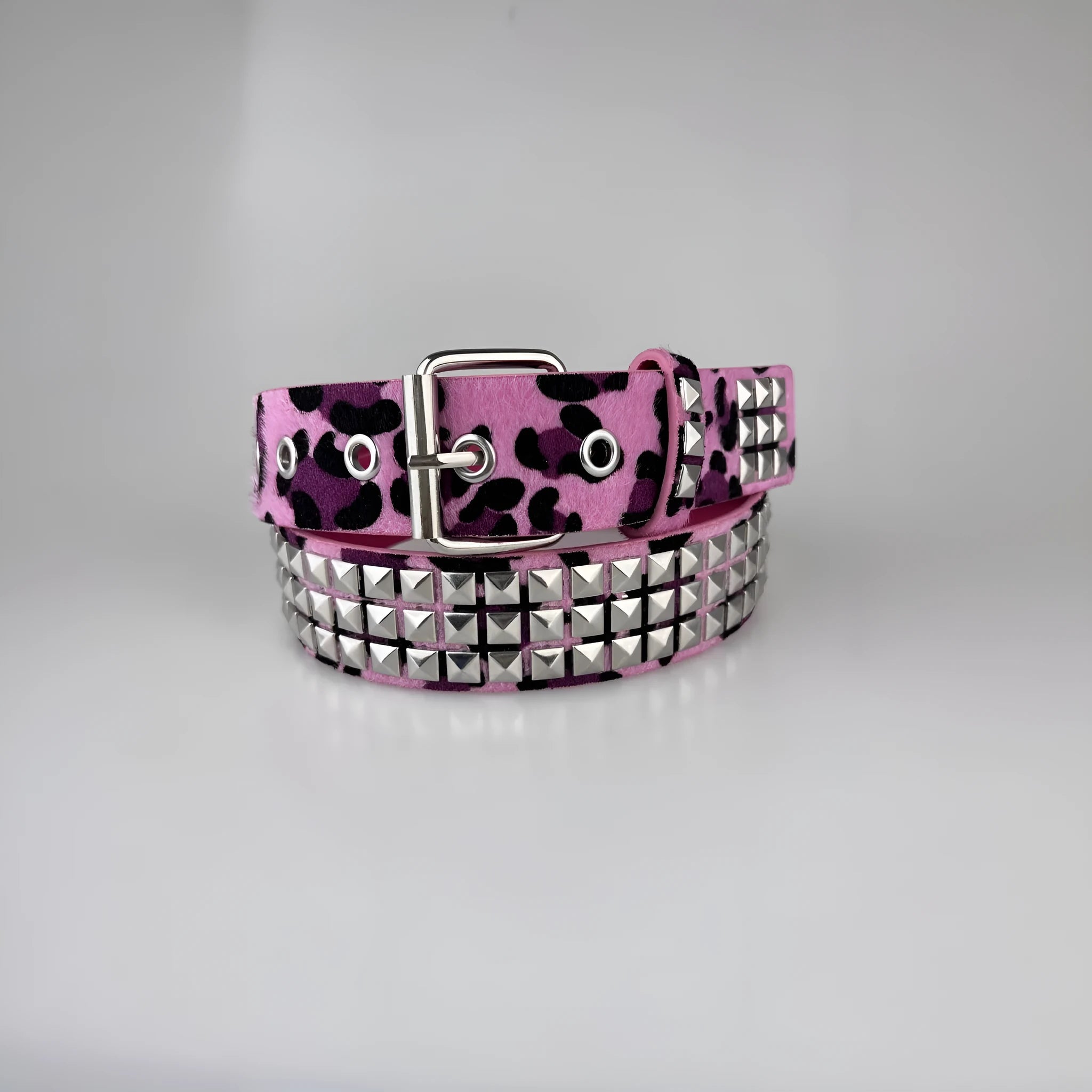 Punk women's belt with metal pyramid rivets in animal print patterns, showing pin buckle fastening