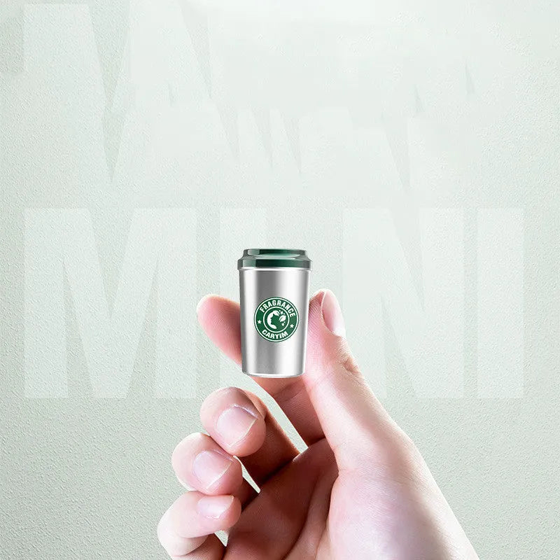 Silver alloy coffee cup shaped solid Gulong perfume seat with natural plant extract on a flat surface