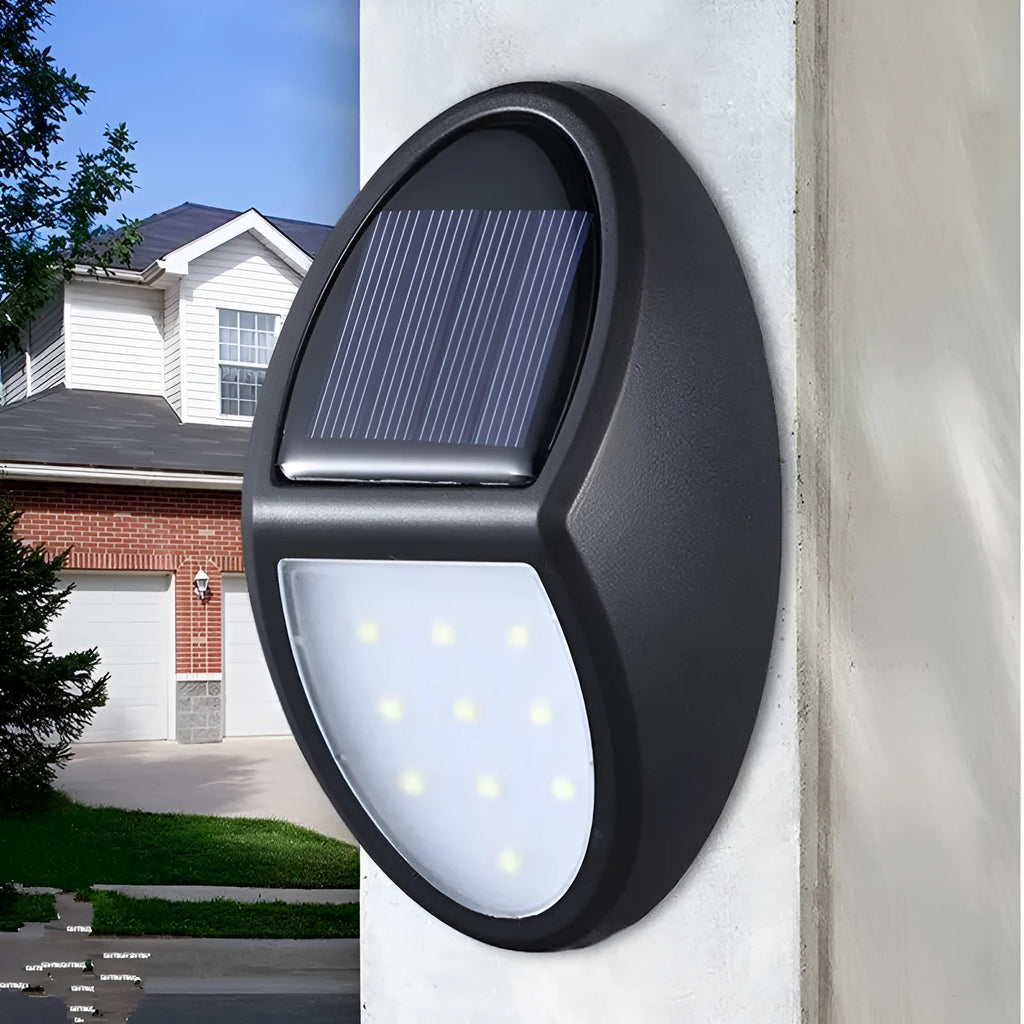 Black rectangular LED solar wall light with solar panel, shown mounted on an outdoor wall.