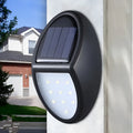 Black rectangular LED solar wall light with solar panel, shown mounted on an outdoor wall.