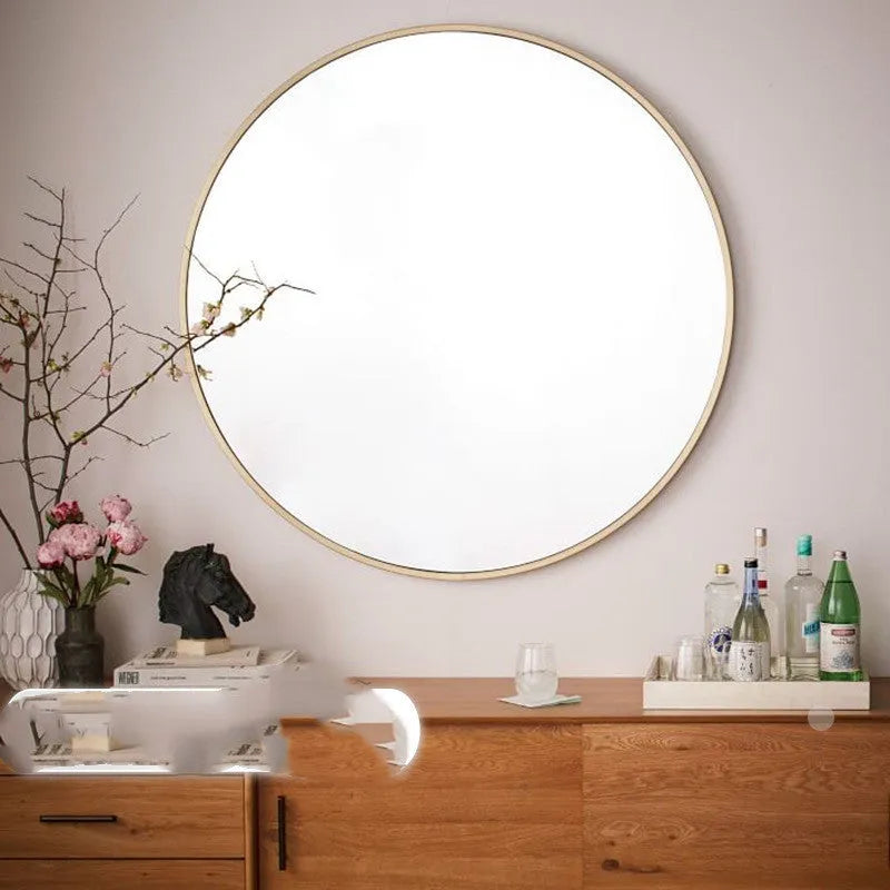 Round metal wall mirror in black finish, shown on a bathroom wall.