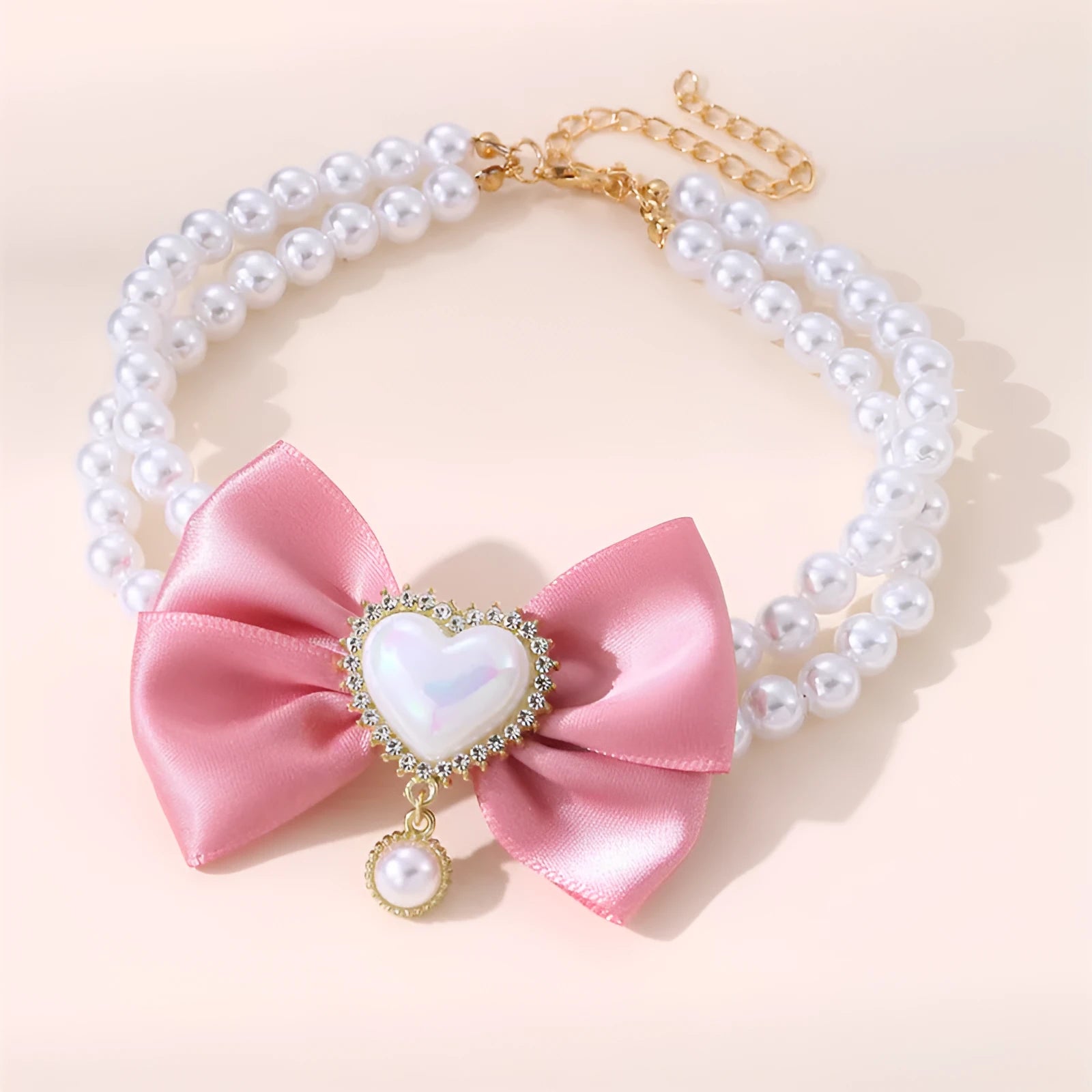 Heart shaped princess style pet necklace with pearl beads in pink on a white background