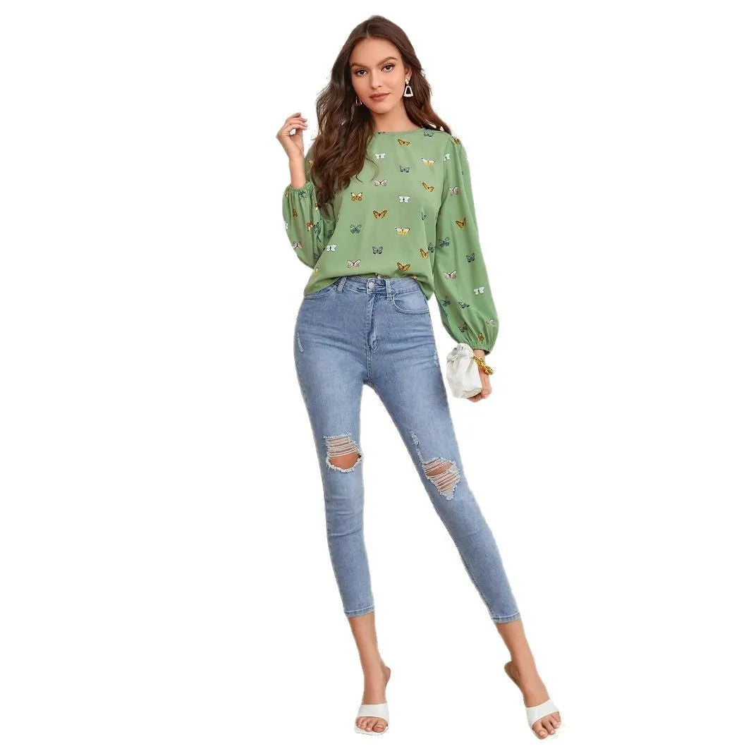 Green women's long sleeve shirt with butterfly print, showing loose fit and button front.