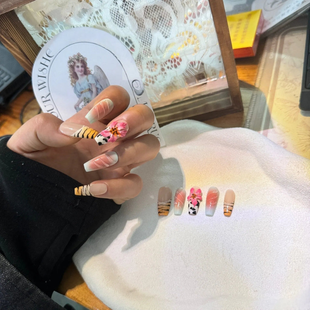 Hand-carved artificial nails with raised zebra pattern and floral designs, shown in long style.