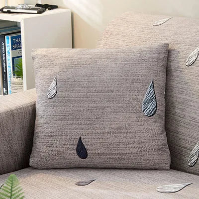 Geometric patterned stretch sofa slipcover on a modern three-seater sofa.