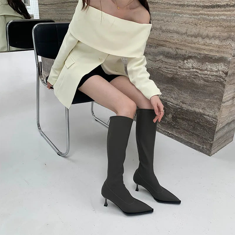 Black women's below-the-knee boots with pointed toe, stiletto heel, and a back zipper.