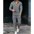 Men's grey sports and leisure loose suit set with polyester top and pants on a plain background