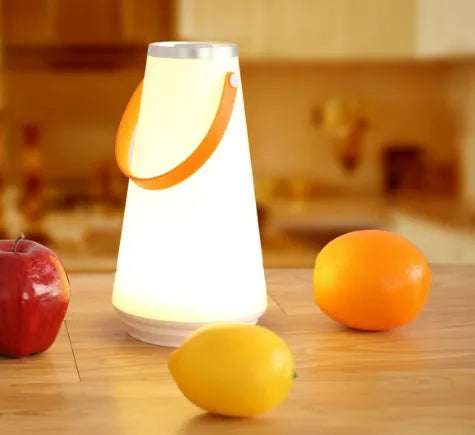 White rechargeable LED table lamp with USB cable on a wooden surface.
