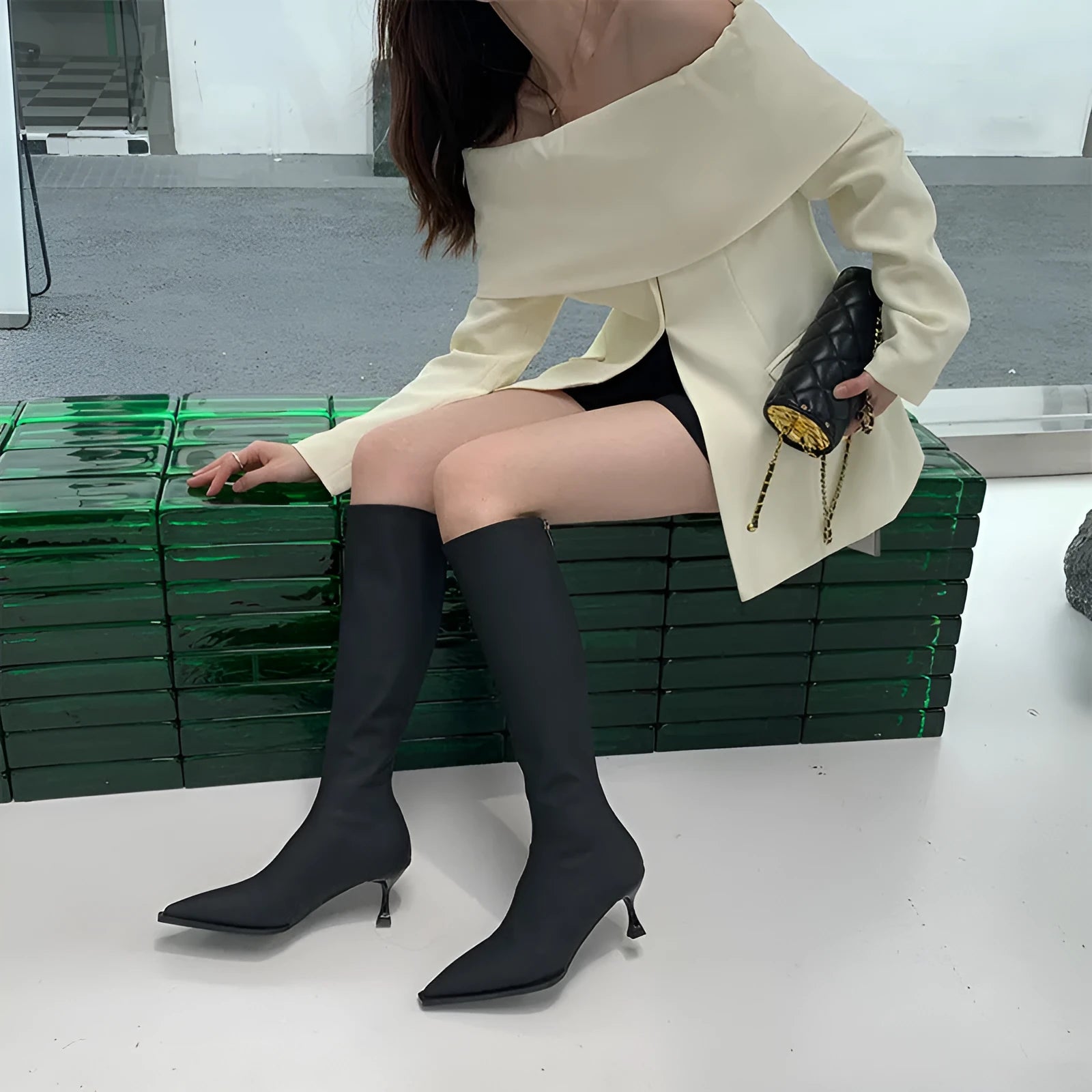 Black women's below-the-knee boots with pointed toe, stiletto heel, and a back zipper.