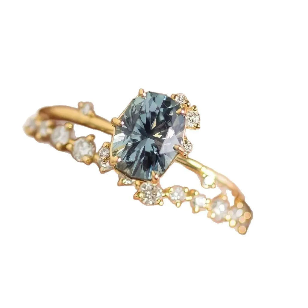 Gold plated floral women's ring with inlaid green zircon stones on a white background.