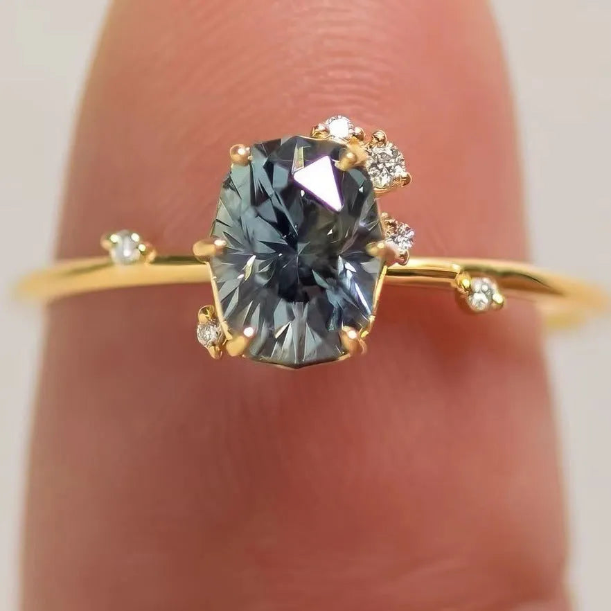 Gold plated floral women's ring with inlaid green zircon stones on a white background.
