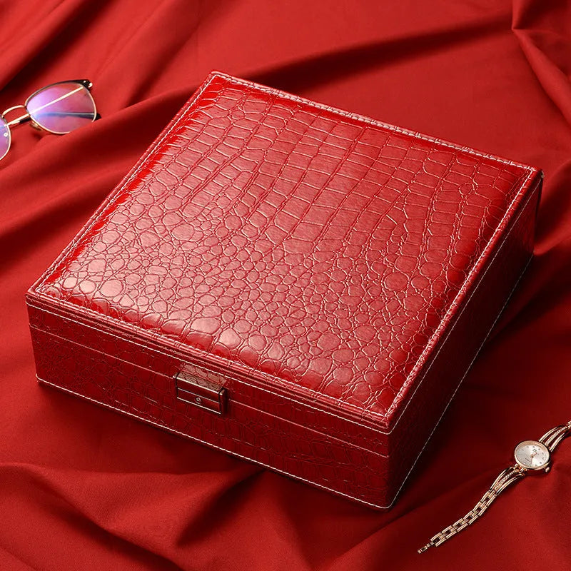 Green leather jewellery storage box with crocodile pattern, lock, and open double-layer interior.