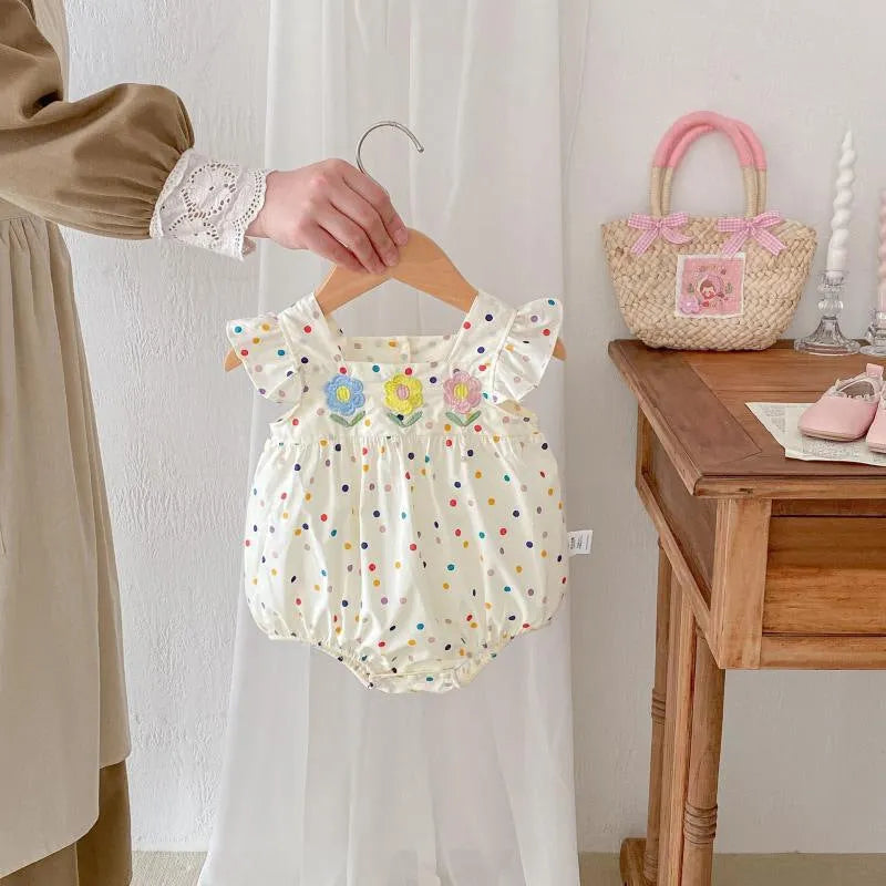 Beige cotton newborn summer jumpsuit with polka dots and flounced sleeves on white background