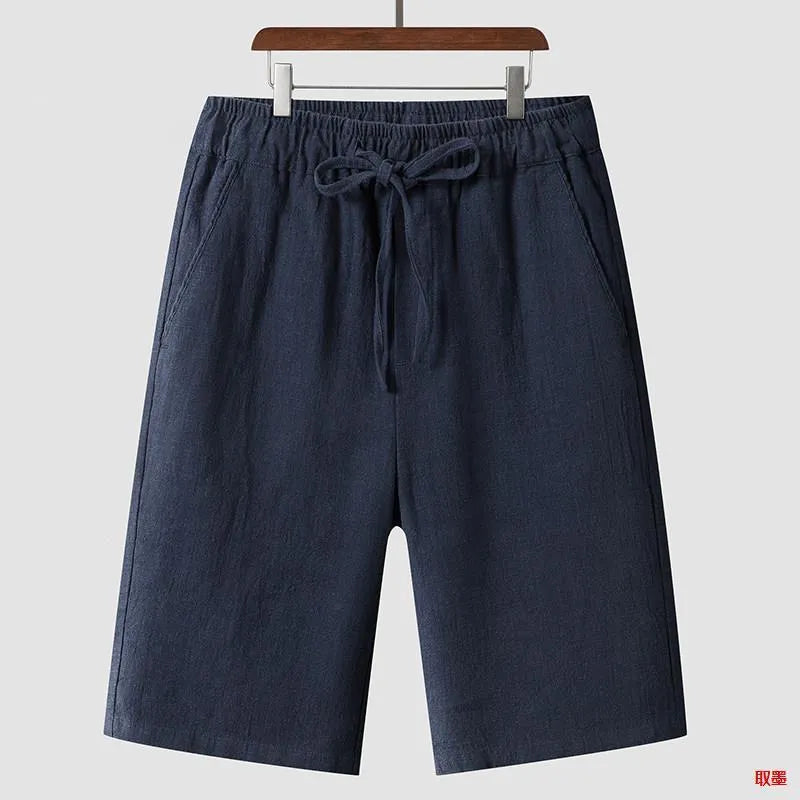 Man wearing beige loose-fit linen cropped shorts with an elastic mid waist.