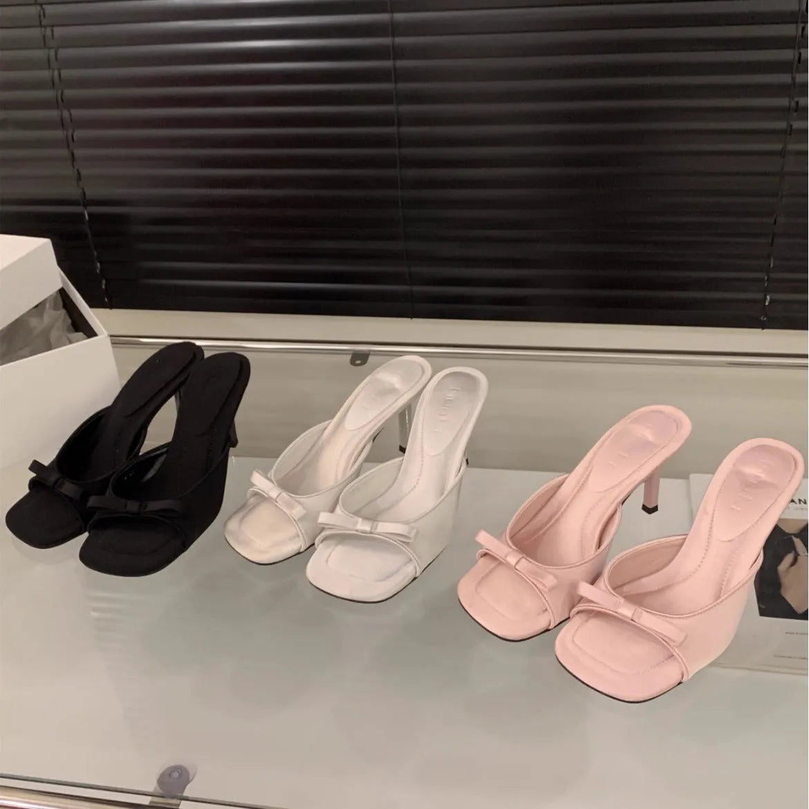 Square head fairy bow high heel slippers with ankle strap in beige on display.