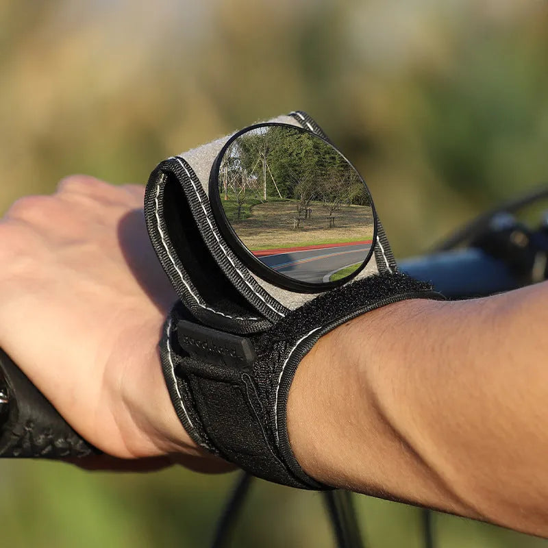 Black wrist-mounted bicycle rear-view mirror with adjustable nylon strap for cycling safety