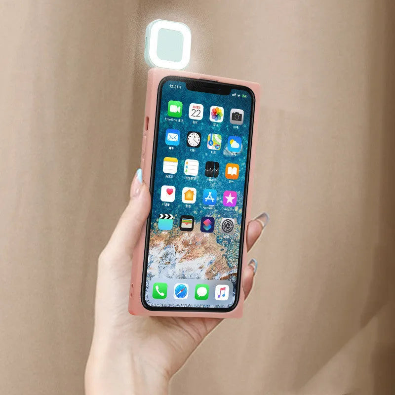 Pink mobile phone case with a ring flash light for Apple iPhone 13 models on a white background.