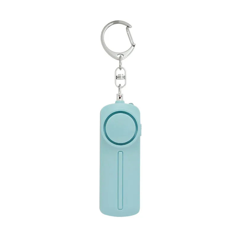 A pink personal safety alarm showing its compact size next to a set of keys.