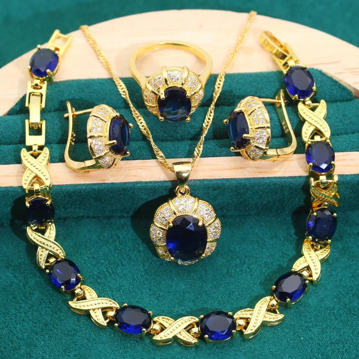 Gold plated cubic zirconia jewellery set with necklace, earrings, ring, and bracelet in blue, green, purple, or red.