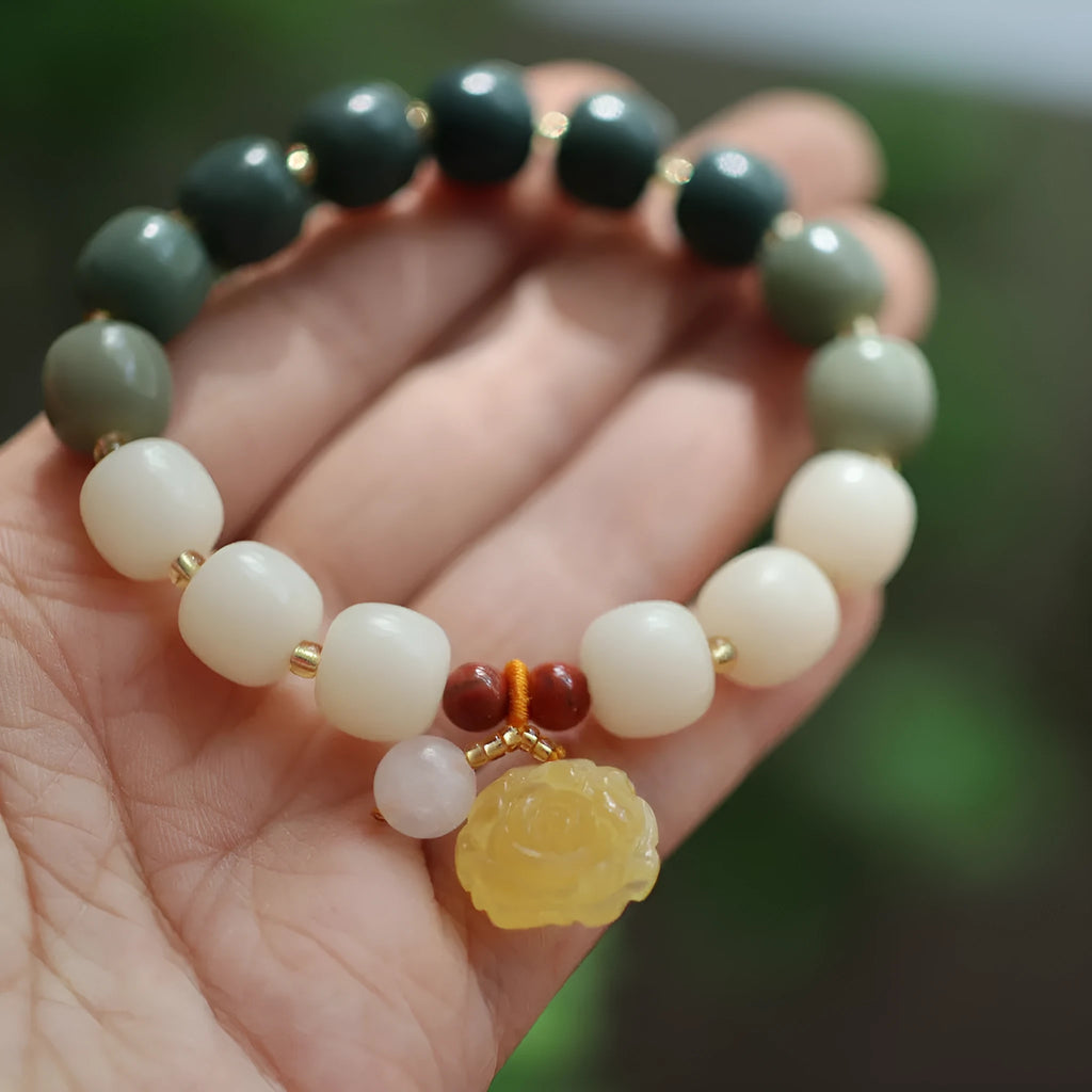 Close-up of a woven gradient white jade and Bodhi root bracelet with flower-shaped beads and a lotus accent.