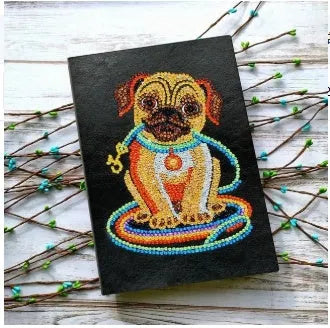 Black A5 hardback diamond painting notebook showing closed cover and spine.