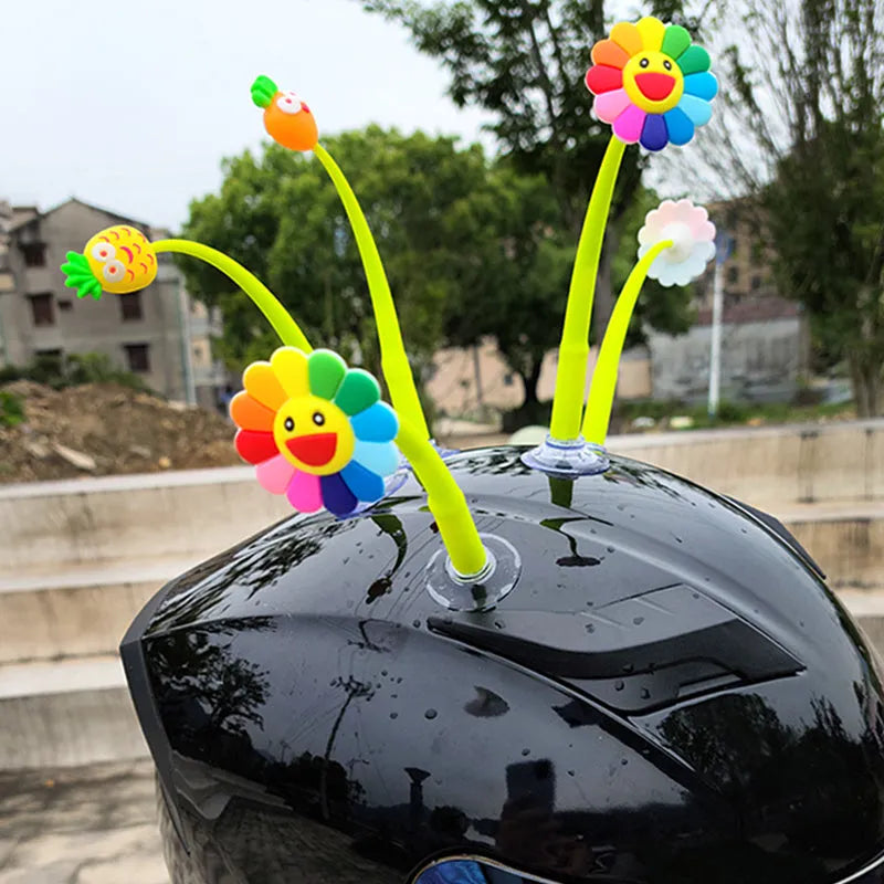 Yellow silicone sunflower decoration with a suction cup base for attaching to a helmet.