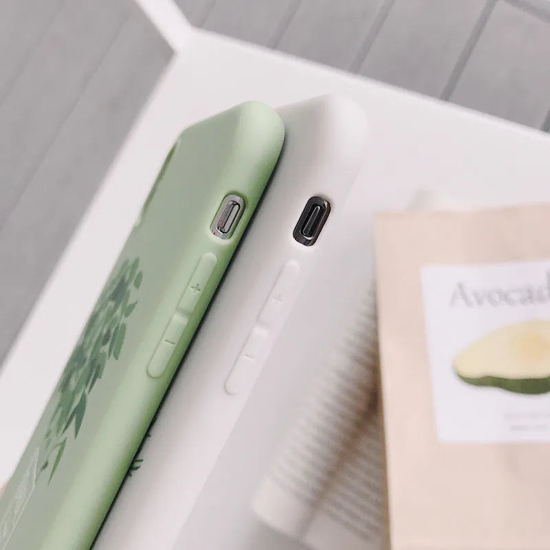 White silicone iPhone case with detailed green painted plant leaves design on the back.
