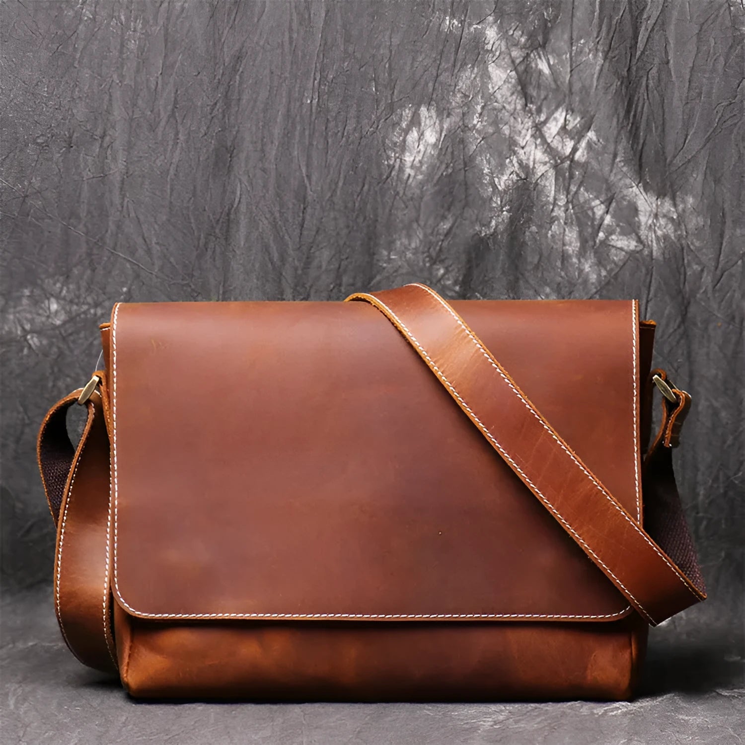 Brown vintage leather men's messenger bag with a shoulder strap showing internal organiser pockets.