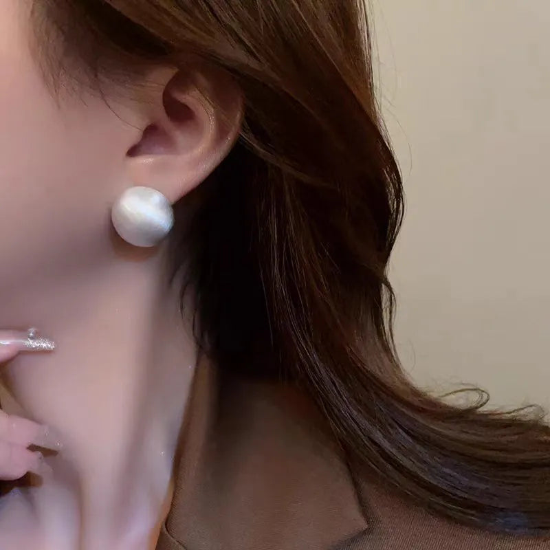 Pair of matte brushed gold bean shaped stud earrings for women with gold and white finish