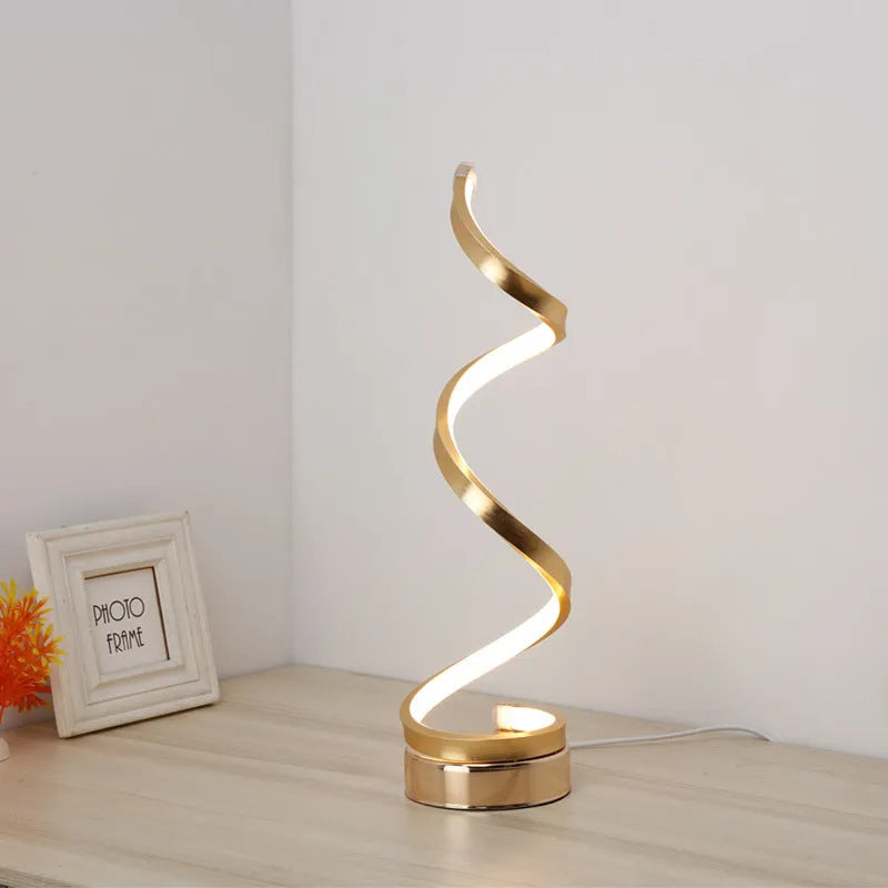 Black and white minimalist LED table lamp with aluminium shade on a desk.